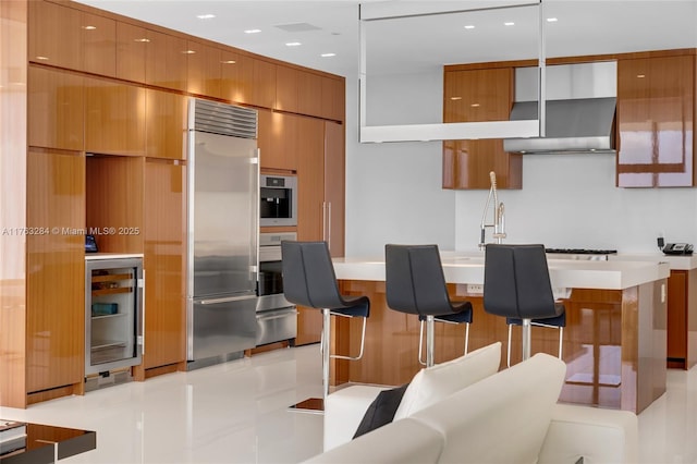 kitchen featuring brown cabinetry, wine cooler, modern cabinets, and stainless steel appliances