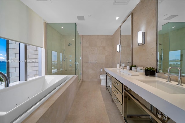 full bathroom featuring a whirlpool tub, a stall shower, tile walls, and a sink