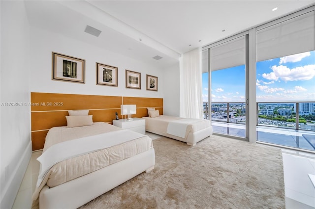 bedroom with access to exterior and a wall of windows