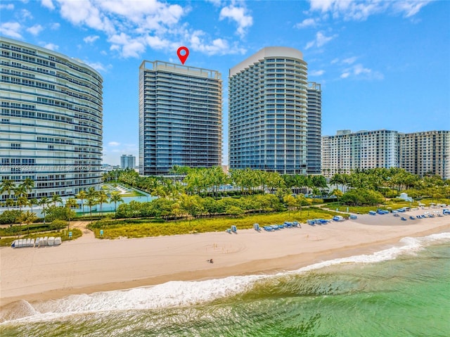 view of building exterior with a city view, a view of the beach, and a water view