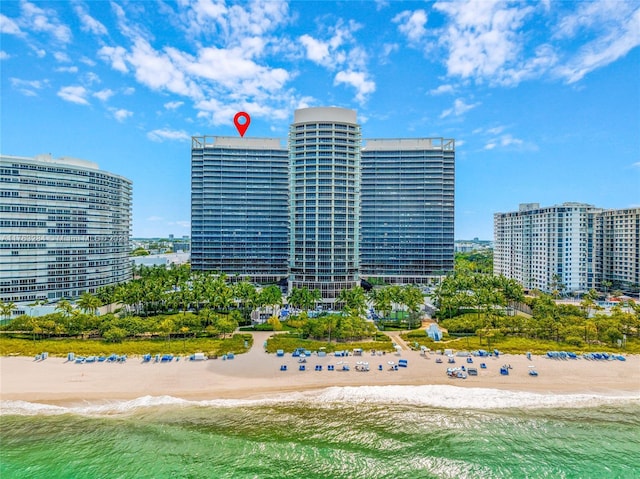 view of building exterior with a view of city, a beach view, and a water view