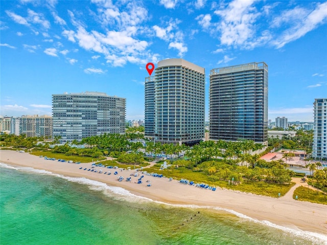 view of property with a city view, a view of the beach, and a water view