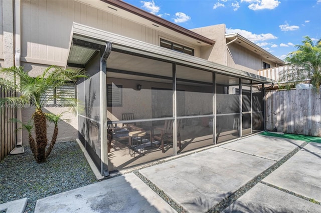 exterior space featuring fence and a sunroom