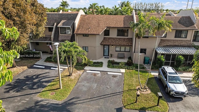 townhome / multi-family property with a residential view, a chimney, and a shingled roof