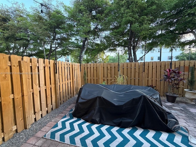 view of patio with fence and a grill