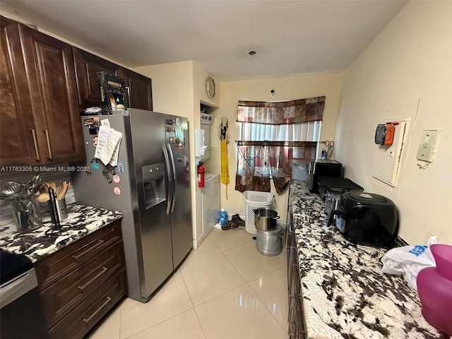 kitchen with dark brown cabinetry, light tile patterned flooring, light countertops, and stainless steel refrigerator with ice dispenser