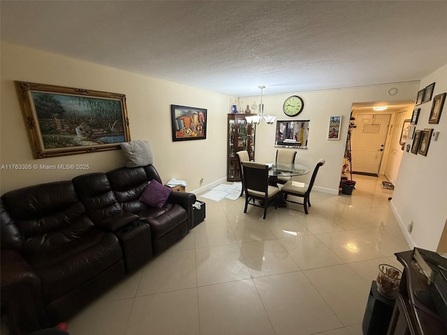 living area with light tile patterned flooring, baseboards, a chandelier, and a textured ceiling