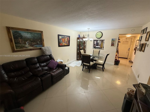 living area featuring light tile patterned floors, a textured ceiling, and baseboards