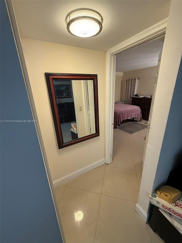 hall with light tile patterned floors and baseboards