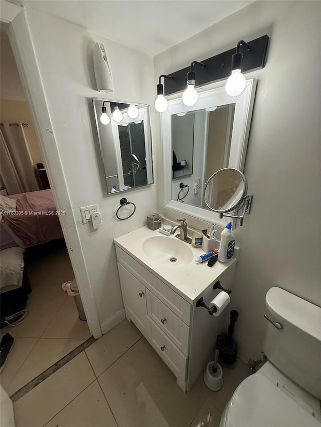 bathroom featuring tile patterned floors, toilet, vanity, and baseboards