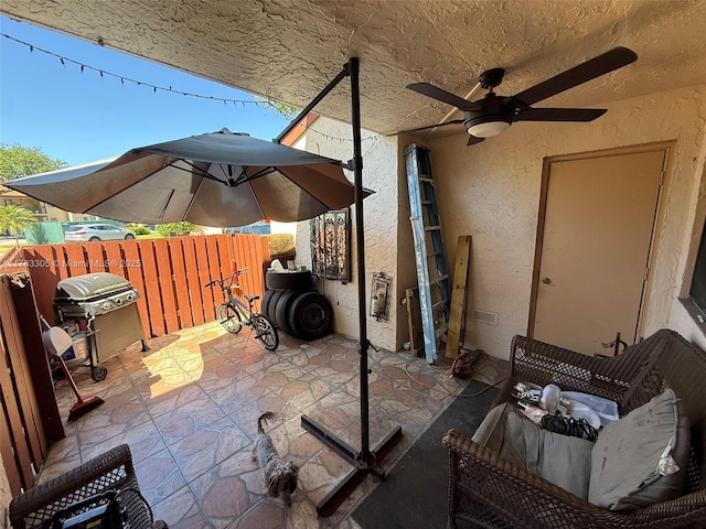 view of patio featuring ceiling fan, fence, and grilling area