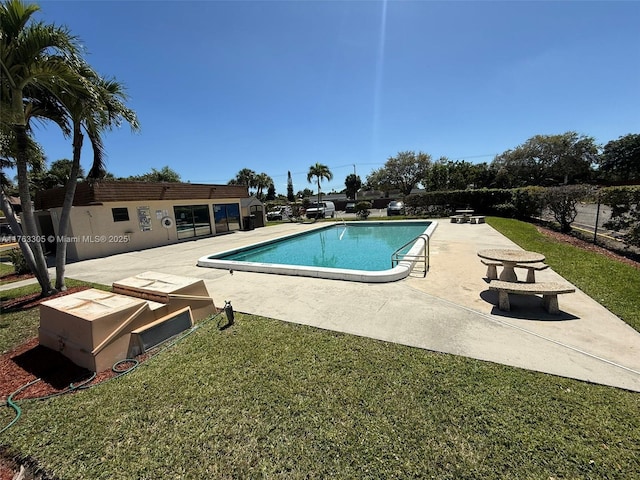 pool with a patio and a lawn