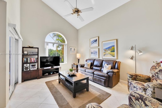 living area featuring high vaulted ceiling, light tile patterned flooring, and a ceiling fan