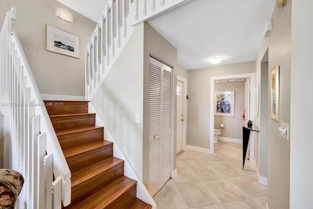 staircase with tile patterned floors and baseboards