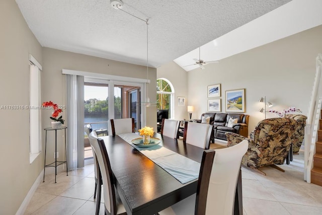 dining room with light tile patterned flooring, a textured ceiling, and lofted ceiling