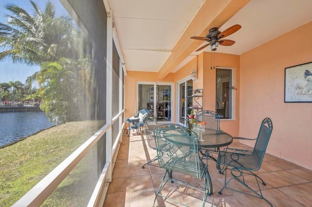 sunroom with a water view and ceiling fan