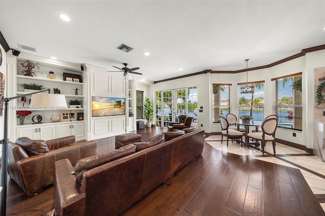 living area with dark wood-style floors, visible vents, a textured ceiling, and baseboards