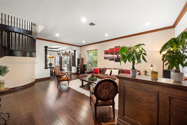 living area featuring hardwood / wood-style floors, visible vents, baseboards, arched walkways, and crown molding