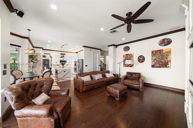 living area featuring a ceiling fan, baseboards, visible vents, and ornamental molding