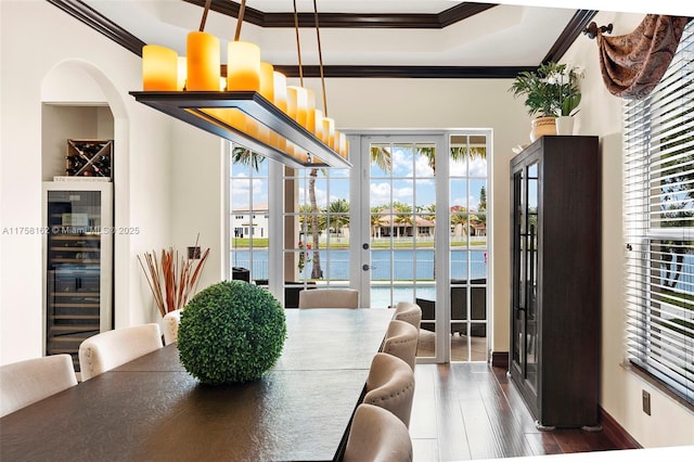 dining room featuring wine cooler, a tray ceiling, ornamental molding, french doors, and dark wood-style flooring