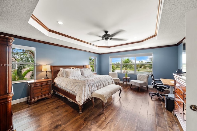 bedroom with a textured ceiling, a raised ceiling, baseboards, and dark wood-style flooring