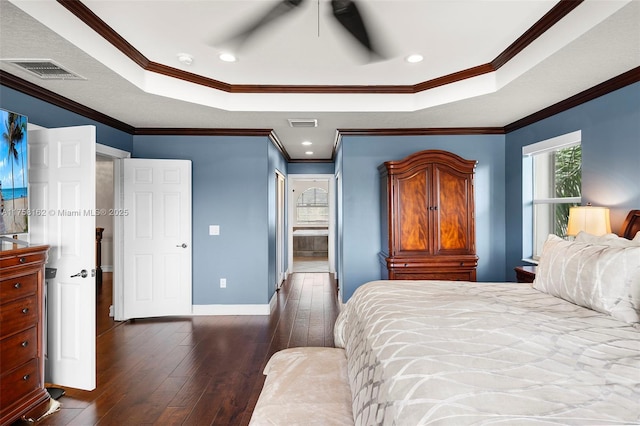 bedroom featuring visible vents, crown molding, baseboards, a raised ceiling, and dark wood-style flooring