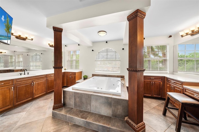 bathroom featuring tile patterned flooring, a jetted tub, vanity, and ornate columns