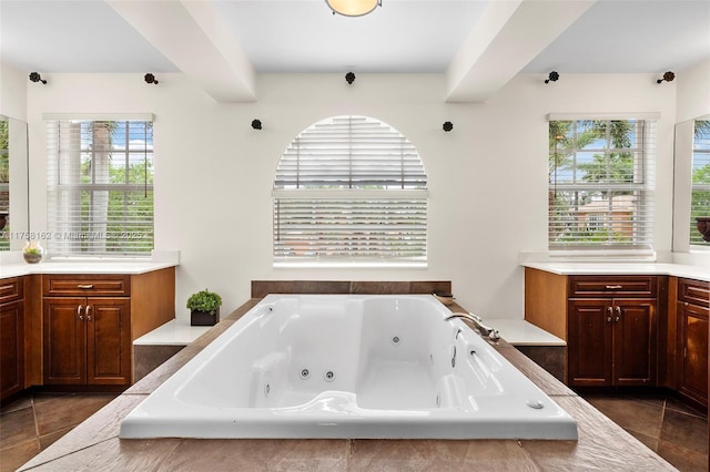 bathroom featuring a tub with jets, vanity, and tile patterned flooring