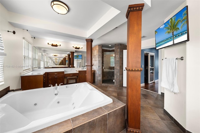 bathroom featuring vanity, decorative columns, a tub with jets, baseboards, and a shower stall