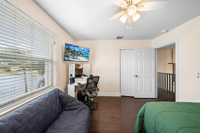 bedroom featuring visible vents, baseboards, ceiling fan, a closet, and dark wood-style flooring