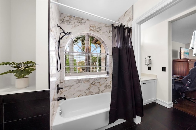 bathroom with baseboards, shower / bath combination with curtain, wood finished floors, and vanity