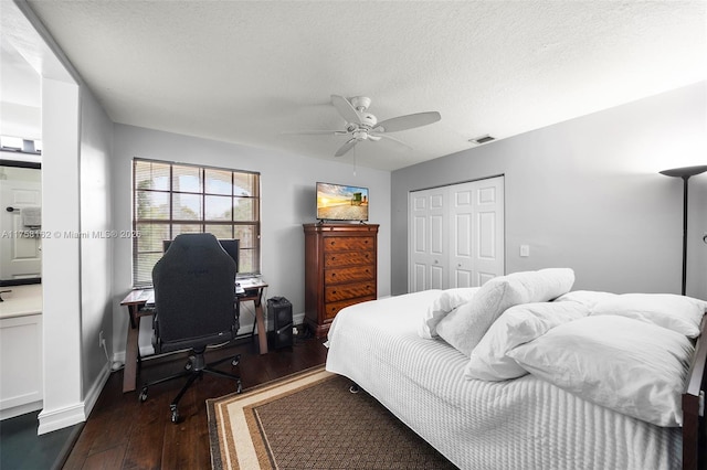 bedroom featuring baseboards, hardwood / wood-style flooring, a closet, a textured ceiling, and a ceiling fan