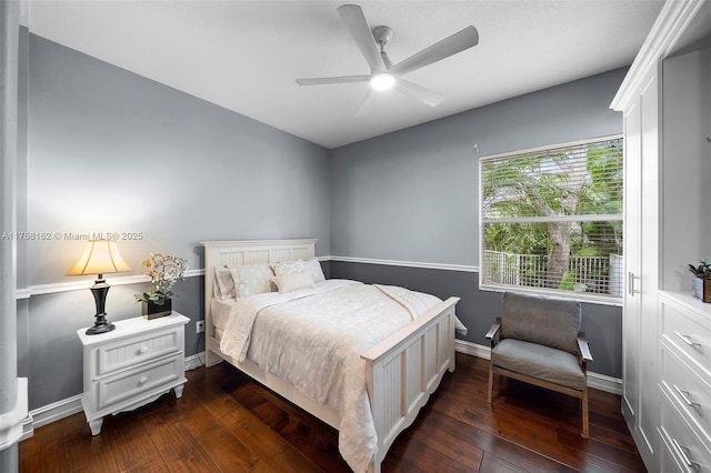 bedroom with dark wood finished floors, a ceiling fan, and baseboards