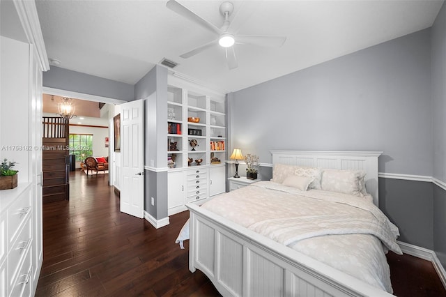 bedroom with visible vents, baseboards, dark wood-style flooring, and ceiling fan with notable chandelier