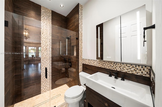 full bathroom featuring vanity, toilet, tile walls, a shower stall, and backsplash