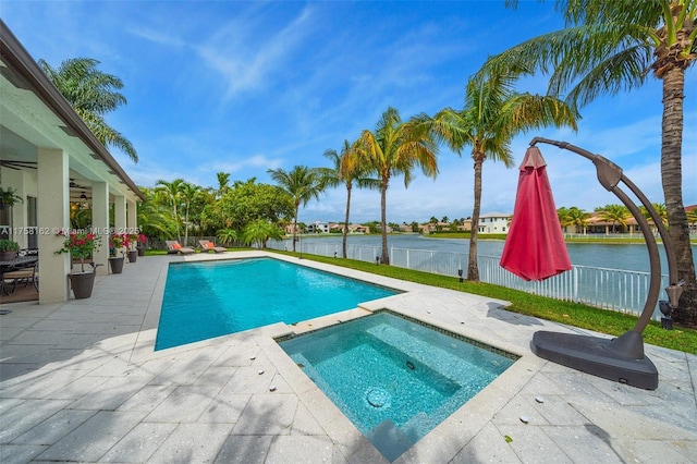 outdoor pool featuring fence, a patio, a ceiling fan, a water view, and an in ground hot tub