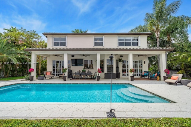 outdoor pool featuring french doors, ceiling fan, an outdoor living space, and a patio area