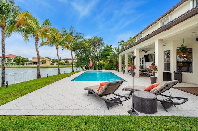 view of pool featuring a patio, a pool with connected hot tub, a ceiling fan, and a water view