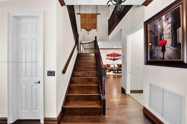 staircase featuring visible vents, baseboards, and wood finished floors