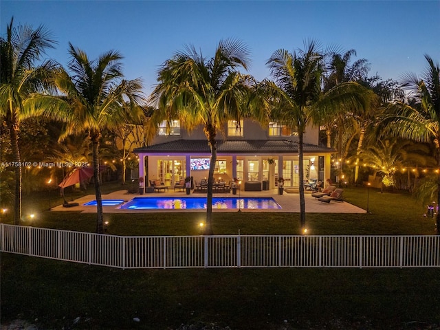 rear view of house with a patio, a fenced backyard, an outdoor living space, a fenced in pool, and a lawn