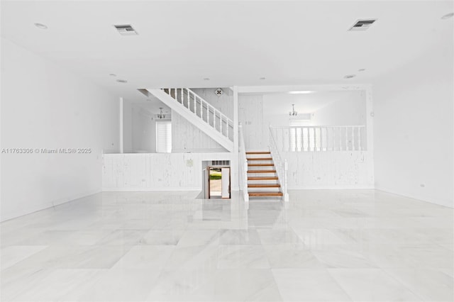 empty room featuring visible vents, stairs, and baseboards