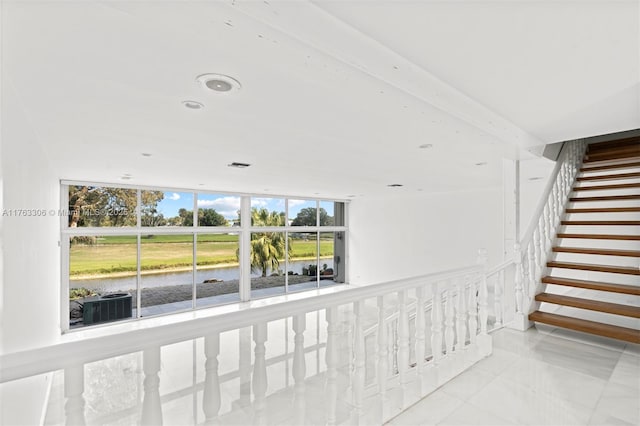 hallway featuring stairs and a water view