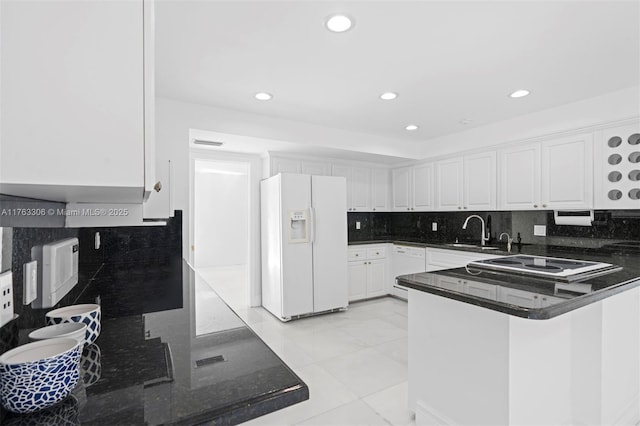 kitchen with a sink, white appliances, tasteful backsplash, and white cabinets