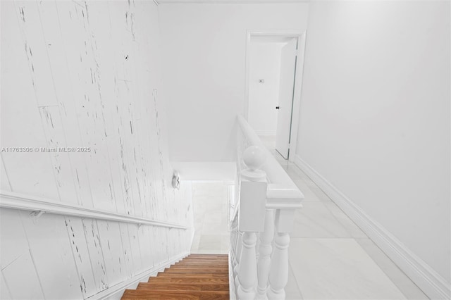 staircase featuring baseboards and wood finished floors