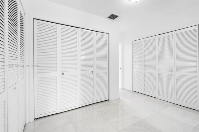 unfurnished bedroom featuring light tile patterned floors and visible vents