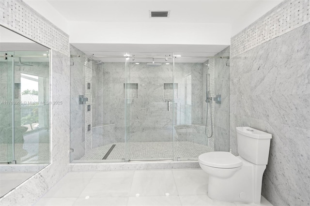 bathroom with visible vents, a stall shower, tile walls, toilet, and tile patterned floors