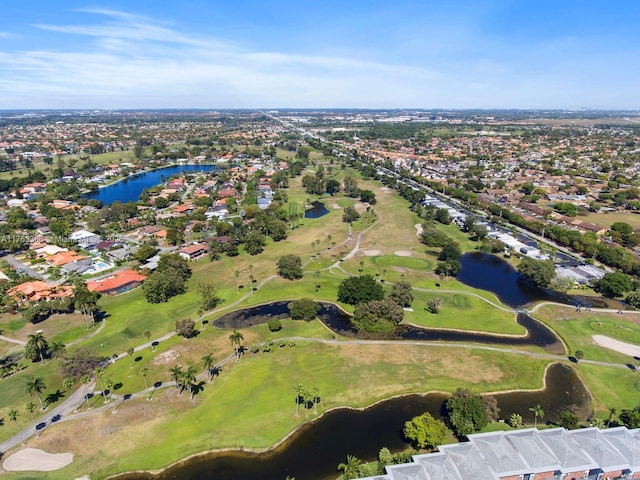 birds eye view of property with view of golf course and a water view