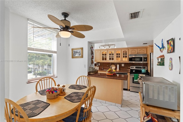 dining space with a textured ceiling, visible vents, and ceiling fan