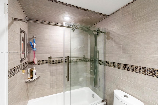 full bathroom featuring toilet and bath / shower combo with glass door