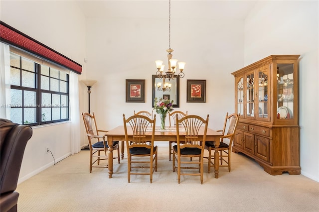 dining area featuring a high ceiling, a notable chandelier, and light colored carpet